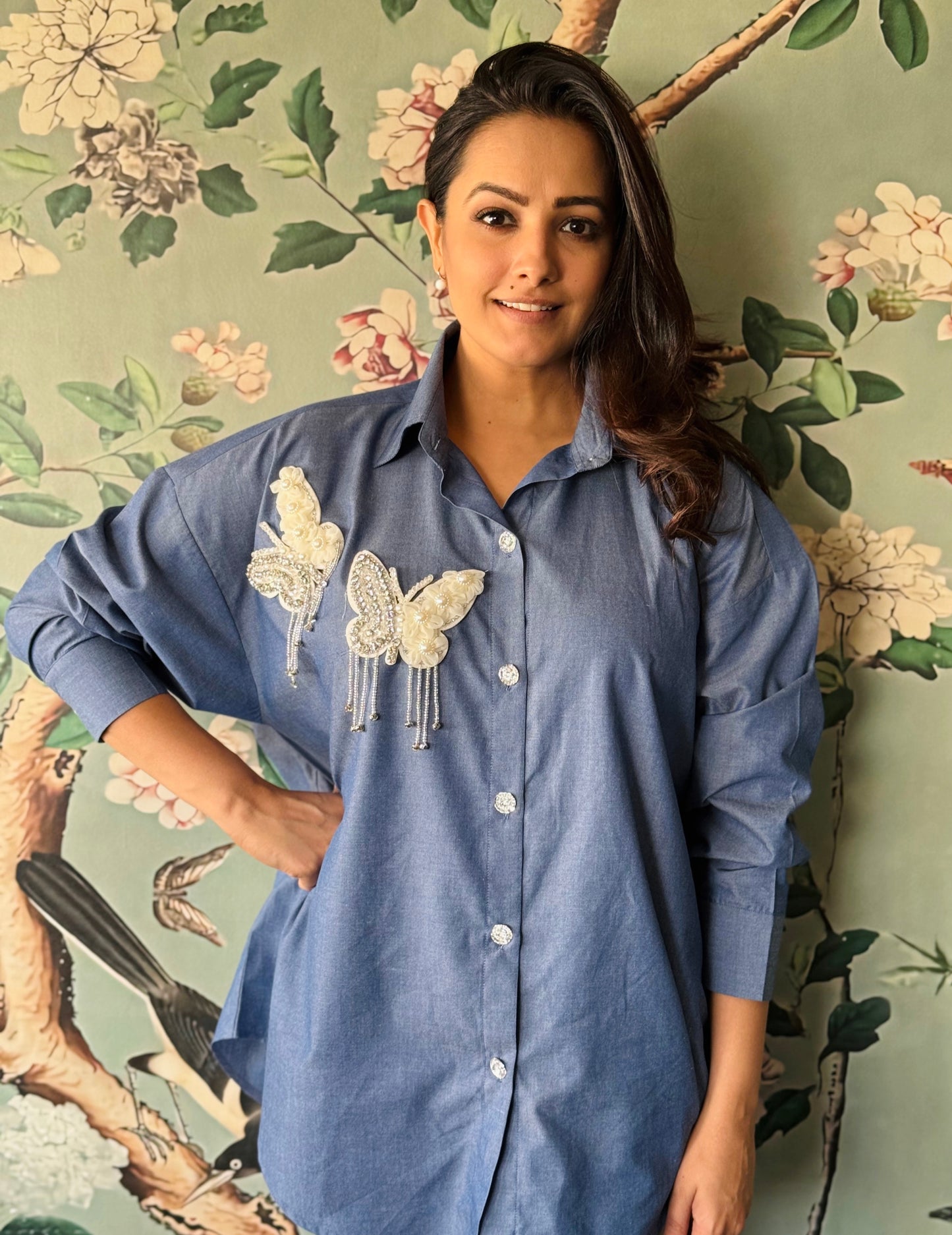 Anita Hassanandani Reddy modeling the Butterfly Dreams Oversized Shirt by Noa - Made with Love, featuring the back view adorned with butterfly patches.